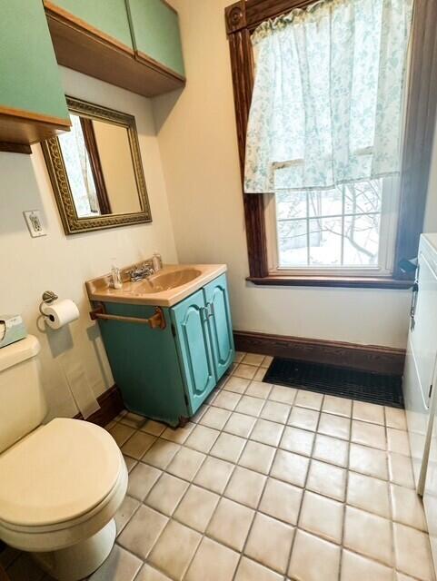 bathroom with baseboards, vanity, toilet, and tile patterned floors