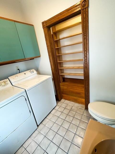 laundry room with laundry area, separate washer and dryer, and light tile patterned flooring