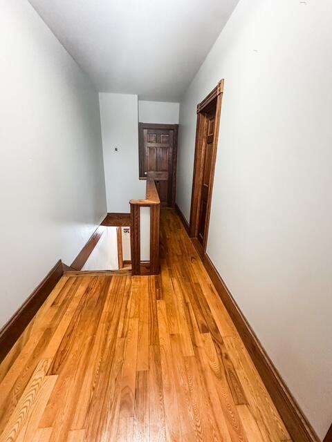 hallway featuring light wood finished floors and an upstairs landing