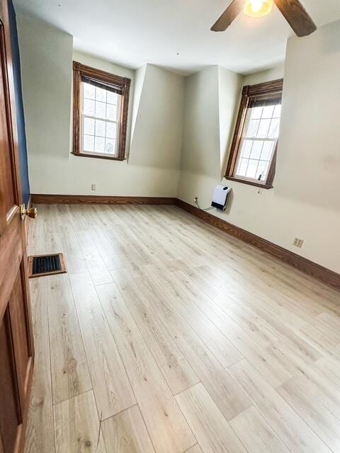 additional living space with visible vents, plenty of natural light, baseboards, and wood finished floors