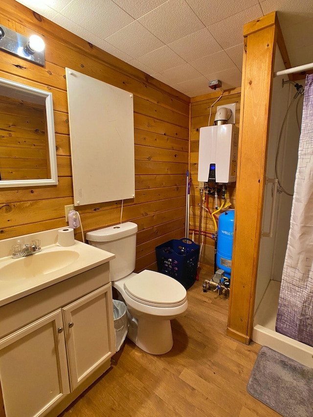 full bathroom with a stall shower, toilet, wood finished floors, tankless water heater, and wood walls