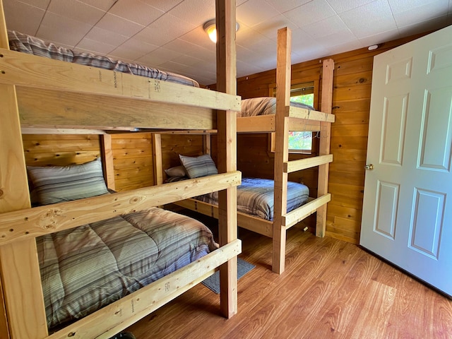 bedroom with wooden walls and wood finished floors