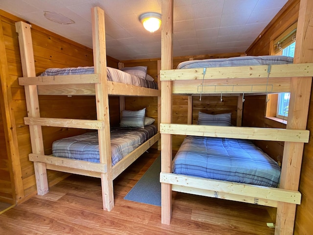 bedroom with wooden walls and wood finished floors