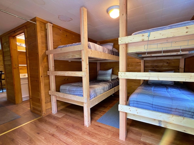 bedroom with wood walls and wood finished floors