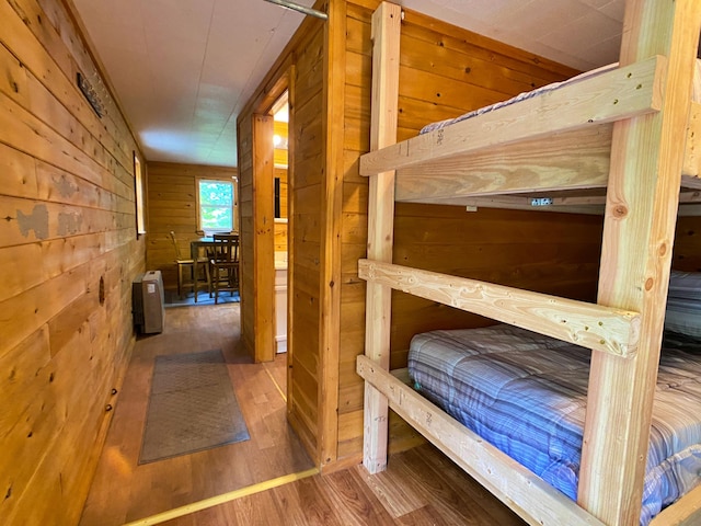 bedroom featuring wood walls and wood finished floors