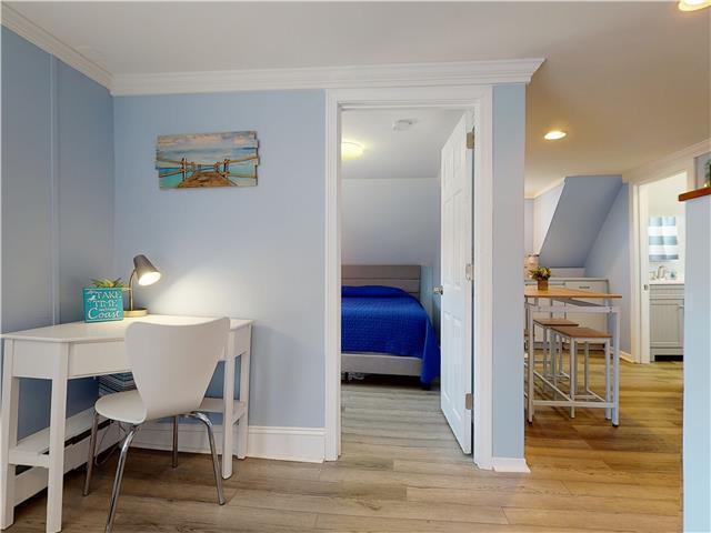 office space featuring baseboards, ornamental molding, and wood finished floors