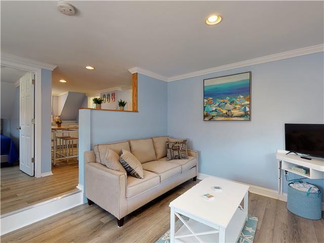 living room with ornamental molding, recessed lighting, baseboards, and wood finished floors