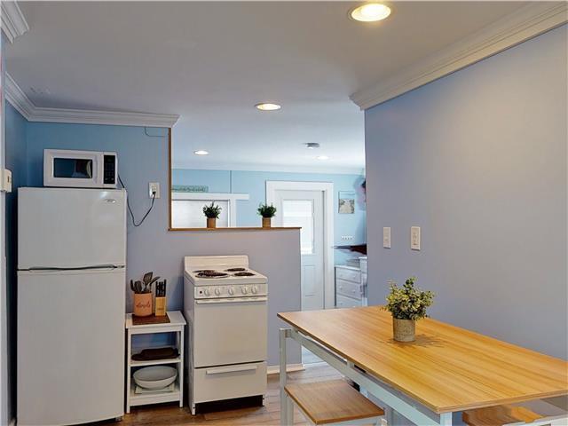 kitchen featuring recessed lighting, white appliances, crown molding, and wood finished floors