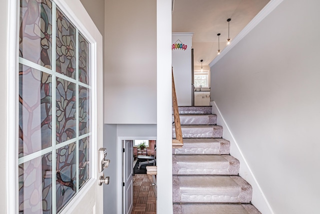 staircase with baseboards and ornamental molding