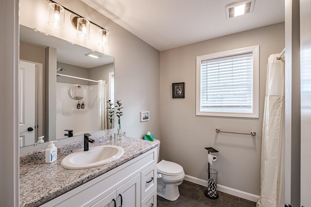 bathroom featuring visible vents, toilet, vanity, a shower with curtain, and baseboards