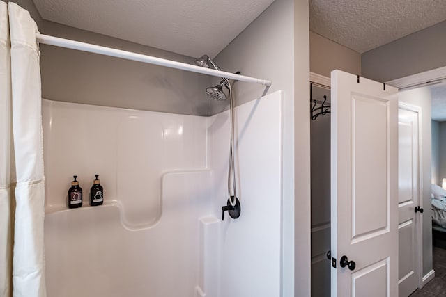 bathroom with a textured ceiling and a shower with shower curtain