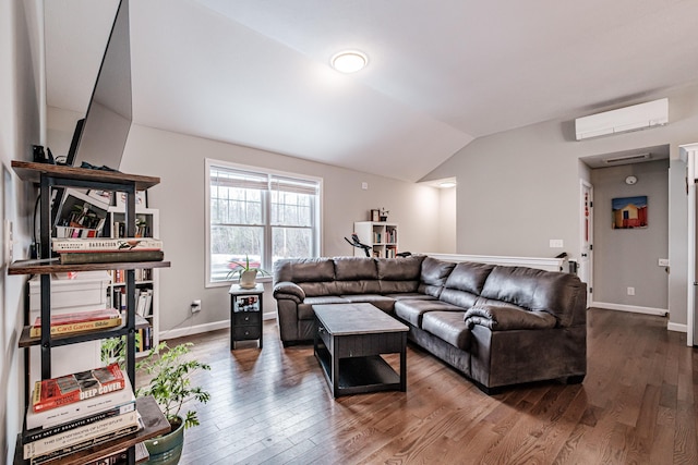 living area with lofted ceiling, baseboards, an AC wall unit, and wood finished floors