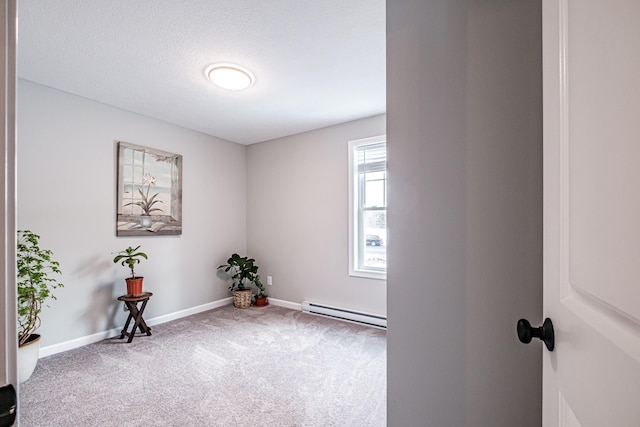 carpeted empty room featuring a textured ceiling, a baseboard radiator, and baseboards