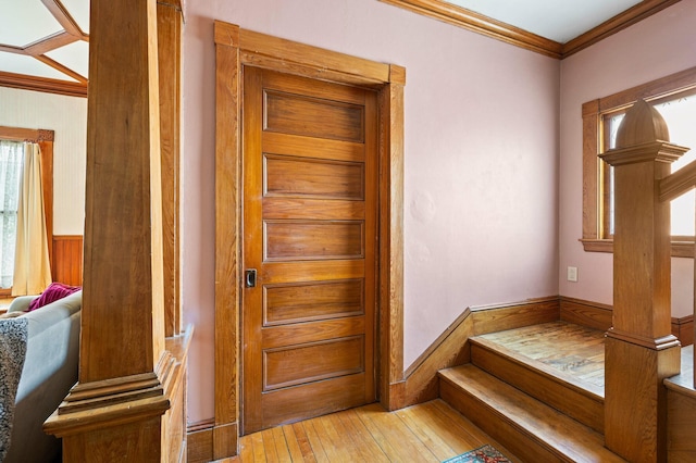 interior space with wood-type flooring, crown molding, and wainscoting
