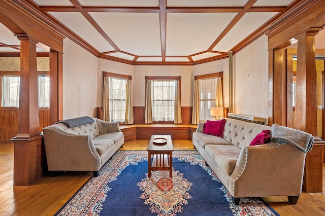 living room with a wainscoted wall, crown molding, hardwood / wood-style flooring, decorative columns, and coffered ceiling