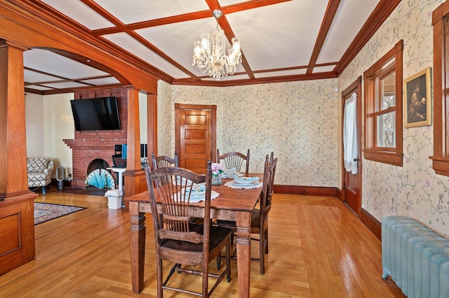 dining room with baseboards, a chandelier, wallpapered walls, light wood finished floors, and radiator heating unit