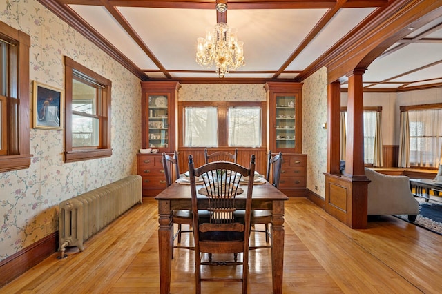 dining area featuring radiator heating unit, wallpapered walls, and ornate columns