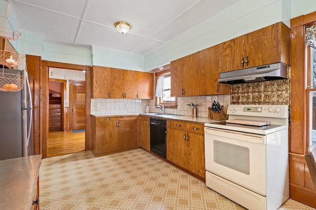 kitchen with white range with electric stovetop, under cabinet range hood, freestanding refrigerator, black dishwasher, and brown cabinetry