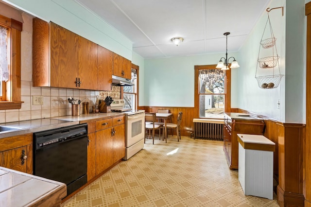 kitchen featuring a wainscoted wall, brown cabinets, black dishwasher, radiator, and white range with electric stovetop