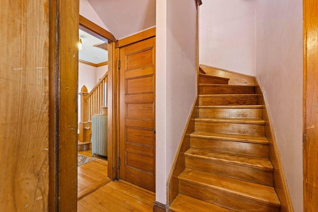 stairway featuring crown molding and hardwood / wood-style flooring