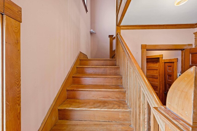 stairway featuring ornamental molding