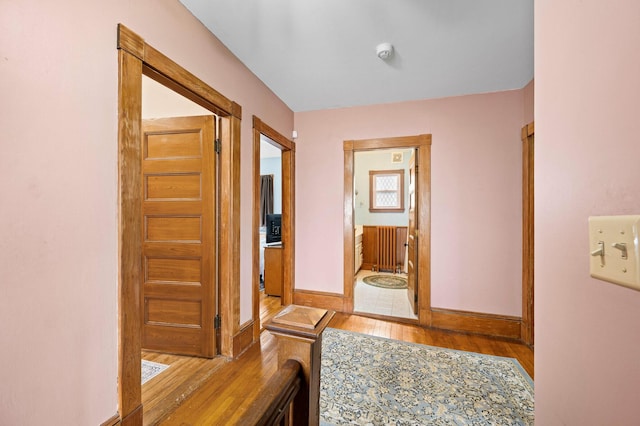 hall with baseboards and wood finished floors
