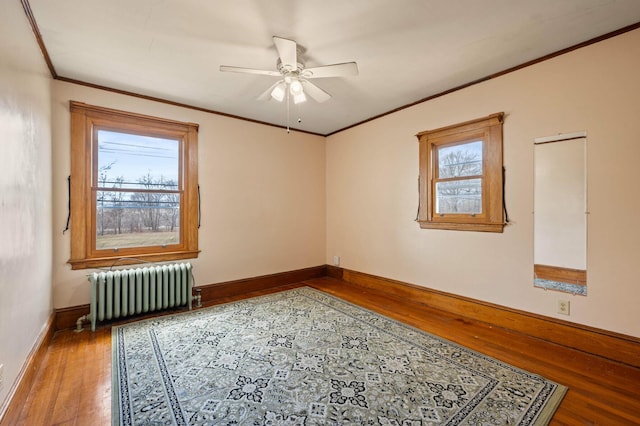 unfurnished room with radiator, crown molding, ceiling fan, and hardwood / wood-style flooring