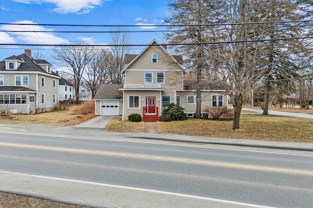 view of front of home with driveway, a garage, a front yard, and a residential view