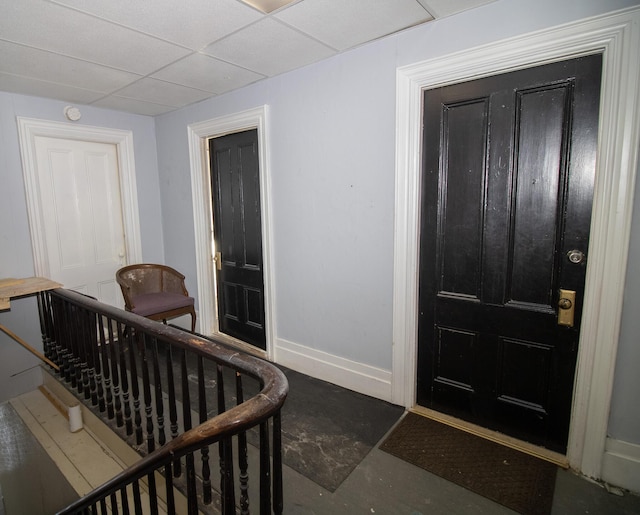 entryway with a drop ceiling and baseboards