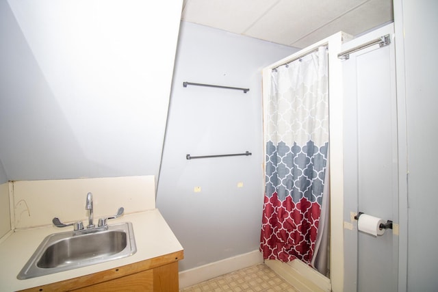 bathroom featuring baseboards, vanity, a shower with shower curtain, and tile patterned floors