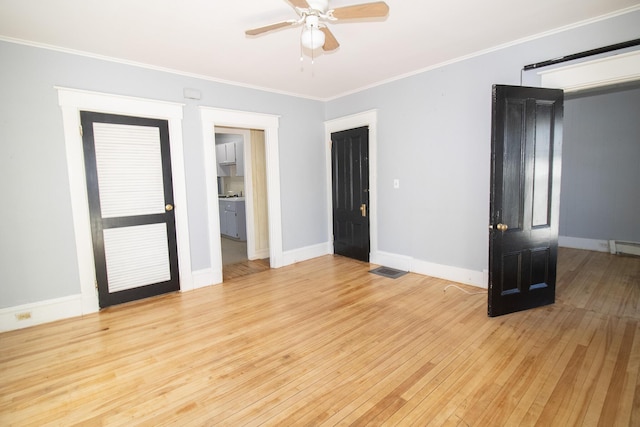 unfurnished room featuring ceiling fan, light wood-style flooring, baseboards, baseboard heating, and crown molding