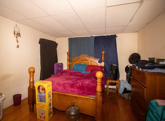 bedroom featuring a paneled ceiling and wood finished floors