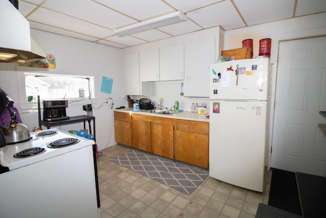 kitchen with white appliances, a sink, white cabinets, light countertops, and brown cabinets