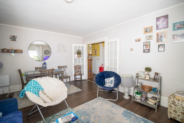 living room featuring crown molding, baseboards, and wood finished floors