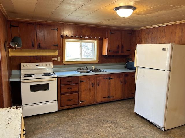 kitchen with brown cabinets, light countertops, a sink, white appliances, and under cabinet range hood