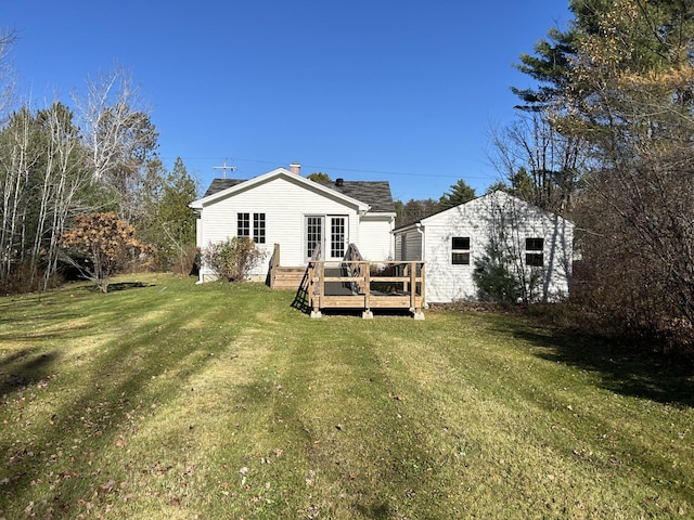 rear view of house featuring a lawn and a wooden deck