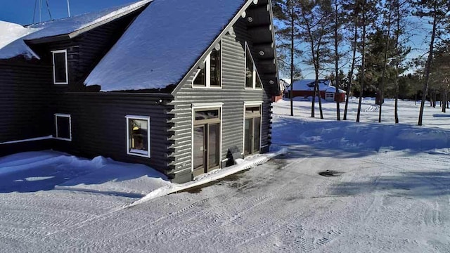 view of snowy exterior with log exterior