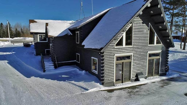 snow covered property featuring log exterior