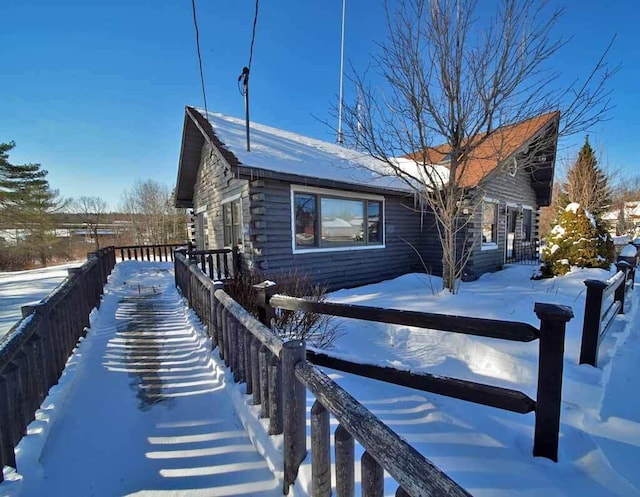 view of snow covered exterior featuring fence