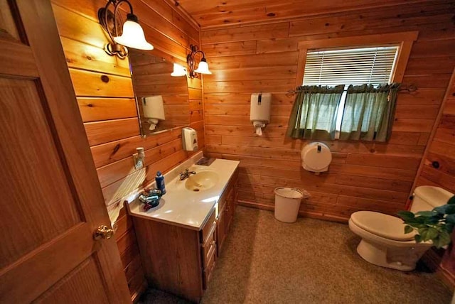 half bath with toilet, wooden walls, and vanity