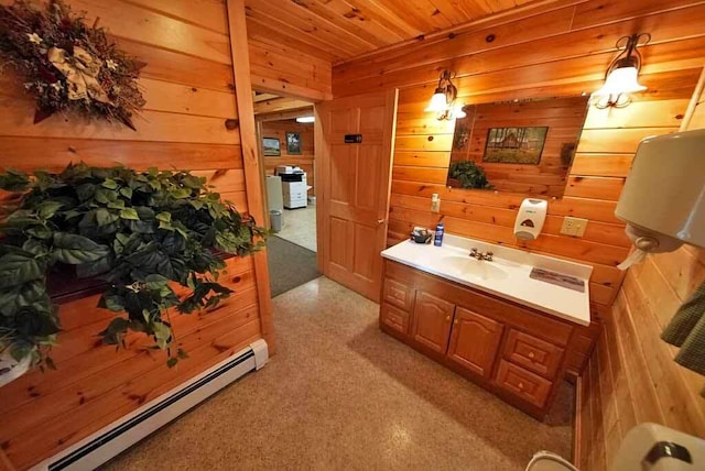 bathroom with a baseboard radiator, wood ceiling, wood walls, and vanity