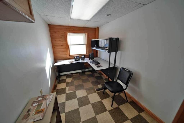 home office with wooden walls, baseboards, a drop ceiling, and tile patterned floors