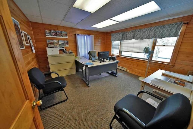 office space with carpet floors, a baseboard radiator, a paneled ceiling, and wooden walls