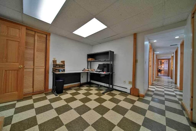 unfurnished office featuring light floors, baseboards, and a drop ceiling