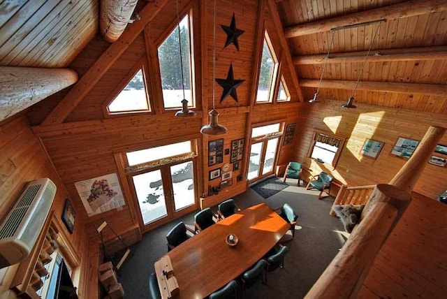 living room featuring french doors, beam ceiling, wood ceiling, wooden walls, and plenty of natural light