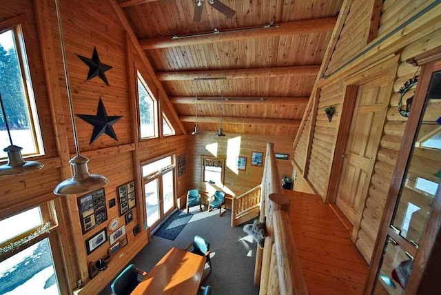 exercise room featuring wood ceiling, a healthy amount of sunlight, vaulted ceiling, and wooden walls