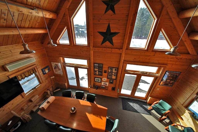 carpeted dining area with french doors, beamed ceiling, wooden ceiling, and wooden walls