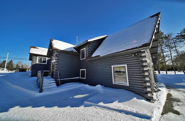 view of snowy exterior with log exterior