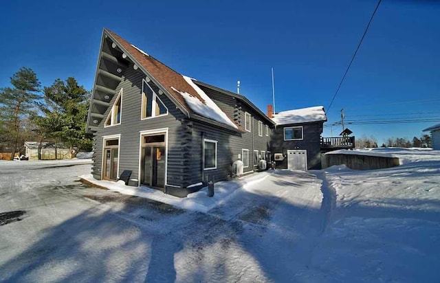 view of snow covered exterior with log siding