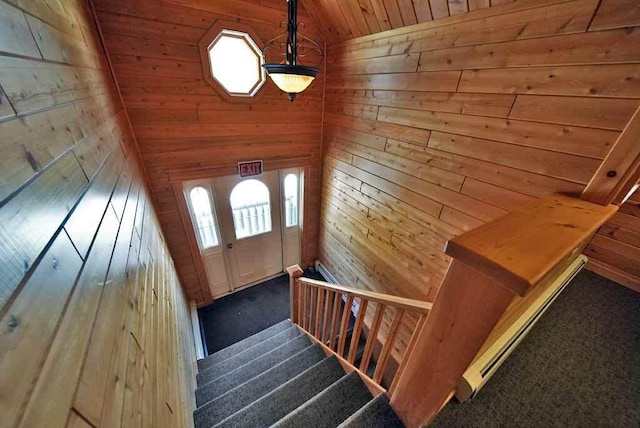 stairway featuring wooden ceiling, wooden walls, vaulted ceiling, and carpet flooring